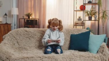Genç kız annesinin telefonunu alıp, oyun oynarken kıkırdıyor. Heyecanlı bir şekilde. Çocuk çocuk kanepede bağırıyordu. Yaptım ve telefonumu sevinçle salladım. Zaferi kutladım.