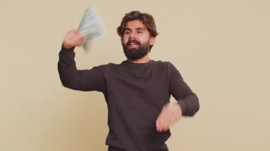 Zengin, yakışıklı patron, hayran, başarılı iş kariyeri, piyango talihlisi, büyük gelir ve servet gibi banknotlar sallıyor. Yetişkin Hintli adam bej arka planda izole edilmiş..