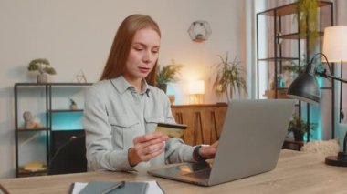 Banka kredi kartı ve dizüstü bilgisayarını merkez ofisteki online alışveriş ödemeleri için kullanan Kafkasyalı mutlu bir serbest kadın. İş anlaşması. E-bankacılık uygulaması ile gülümseyen kız alışverişi.
