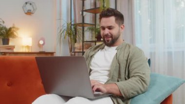 Kahverengi saçlı, dizüstü bilgisayar kullanan, postayla iyi haber mesajı alan sürpriz beyaz adam evinde online alışveriş yaparak piyango galibiyetini kutlarken şok oldu. Yaşam Tarzları.