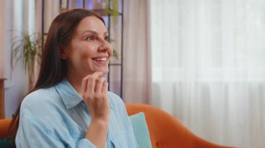 Kanepede oturup patlamış mısır yiyen ve ilginç TV dizileri, spor oyunları, filmler, evdeki çevrimiçi sosyal medya filmi içeriklerini izleyen mutlu bir kadın. Kız ev eğlencesinden hoşlanıyor.