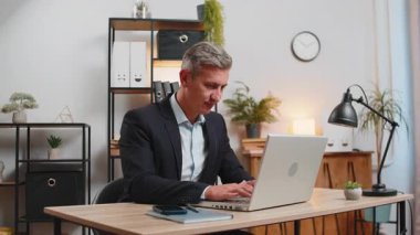 Dizüstü bilgisayar ağı üzerinde çalışan genç, beyaz bir işadamı. Ani zaferle gülümsüyor, gol başarısı, galibiyet, kariyer haberleri. Takım elbiseli serbest çalışan heyecanlı bir adam çalışma masasında oturuyor.