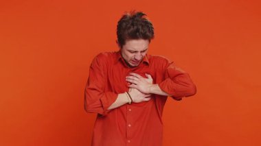 Stresli, hasta, hasta, beyaz bir adam göğsünde kalp krizi geçirerek kalp krizi geçirerek kalp krizi geçirerek, kalp krizi belirtileri göstererek, kendini kötü hissederek, kapalı alanda izole edilmiş genç bir adam.