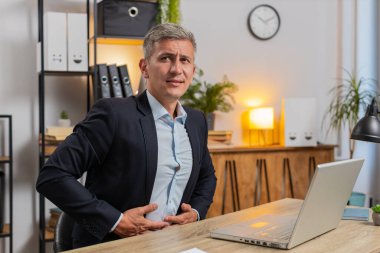 Takım elbiseli Kafkasyalı genç işadamı iş sırasında ev bilgisayarında aşırı yemek yerken hayal kırıklığına uğradı. Sinirli stil sahibi, serbest çalışan, karnına dokunan, rahatsız ve keskin bir ağrı hisseden biri..