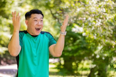 Aman Tanrım, vay canına. Şaşırmış atletizm koşucusu ağzı açık bir şekilde, ani bir zaferle şoka girmiş bir şekilde yan tarafa bakıyor. Parkta kardiyo antrenmanı. Aktif Japon sporcu adam motivasyonu.