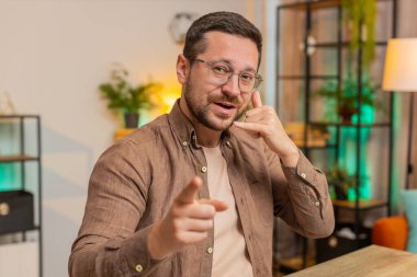 Beni ararsın. Genç Kafkasyalı patron iş adamı dizüstü bilgisayarını kullanarak telefon görüşmesi yapmak istiyor, bana işaret veriyor, online randevu. Ofisteki serbest çalışan adam oturma odasındaki kameraya bakıyor..