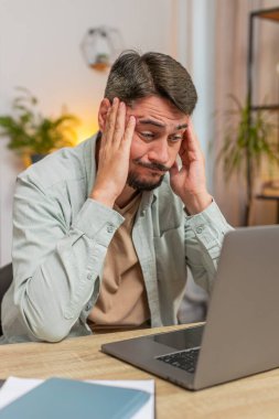 Evde çalışırken bilgisayar kullanan öfkeli, serbest çalışan bir adam iş yerinde sinir krizi geçiriyor, stres yönetimi, zihinsel stres sorunları, kendini kaybetmek, başarısızlığa tepki vermek. Dikey.