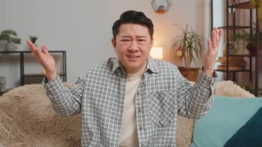 Avuç içi. Yazıklar olsun sana. Üzgün adam saygısızca bir jest yapıyor. Başarısız olmaktan sıkılıyor. Kötü haber. Oturma odasında kanepede oturan Orta Doğulu adamın portresi. Yaşam Tarzları.