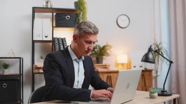 Genç işadamı ofis projesini bitirdikten sonra bilgisayarını kapatıp masa başında oturuyor. Kafkasyalı serbest çalışan, modern ofiste uzaktan kumandalı iş yapıyor. Netbook bilgisayarında gezinme, E-öğrenme İnternet.