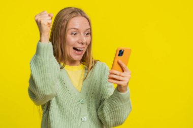 Mutlu Kafkasyalı genç kız akıllı telefon daktilo kullanıyor bağırarak evet de büyük ikramiye kazan iyi haber piyango hedefi başarıyı kutla, sarı ile oyun kazan