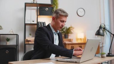 Bilgisayarda çalışan Kafkasyalı zengin bir işadamı nakit para sayıyor, iş yerindeki kazanç gelirlerini hesaplıyor. Resmi takım elbiseli profesyonel menajer serbest çalışıyor. İş adamları.