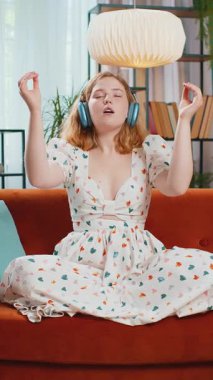 Sakin ol, rahatla, iç denge. Kızıl saçlı kadın derin derin nefes alıyor. Mudra jesti gözleri kapalı. Yoğun düşüncelerle meditasyon yapıyor. Kız kanepede oturur. Dikey