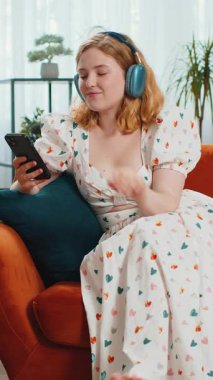 Kızıl saçlı, kablosuz kulaklıklı, mutlu bir kadın evinde koltukta oturup en sevdiği enerjik disko dans müziğini dinliyor. İnsanlar hafta sonları boş zaman aktiviteleri yapar. Dikey