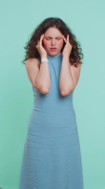 Baş ağrısı, migain, stres, acı, ekşitme, mavi arka planda izole edilmiş yüksek tansiyon gibi sorunları tedavi etmek için tapınakları ovuşturan çekici genç bir kız. Dikey