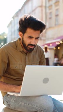 Şehir caddesinde oturan Hintli bir adam dizüstü bilgisayarına bakarak yazı yazarak çalışarak kaybediyor. Ani piyango sonuçlarına şaşırıyor. Oyun, servet kaybı, başarısızlık. Arap adam internetten kötü haber alıyor. Dikey