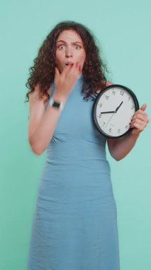 Endişeli bir kadın mesai saatini kontrol ediyor, işe geç kalıyor, gecikiyor, son teslim tarihi. Saatler, dakikalar süren meşgul bir kız. Mavi stüdyo arka planında dakikası dakikasına izole edilmekten endişe ediyor. Dikey