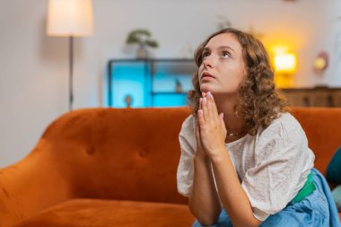 Korkunç haberlerle şoke olmuş, üzgün genç bir kadın, avuç içlerini birleştirip yardım diliyor, stresli olduğunu düşünüyor. Hayattaki sorunlar yüzünden umutsuz görünüyor. Dua ediyor, yardım istiyor. Yaşam Tarzları.