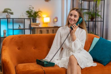 Gülümseyen genç bir kadın evdeki kanepede oturan arkadaşlarıyla telgraflı telefon konuşması yapıyor. 90 'lardan kalma eski moda telefondan hoşlanan mutlu, heyecanlı kız oturma odasında konuşuyor. Yaşam biçimi