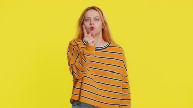 Tartışma. Rahatsız ve hoşnutsuzlukla el kol hareketi yapan, başarısızlıktan dolayı azarlayan, bunun neden olduğunu soran genç bir kadın. Esmer, çekici kız, sarı stüdyo arka planında izole edilmiş.