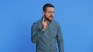 Tartışma. Rahatsız edici ve hoşnutsuzca el kol hareketi yapan, başarısızlıktan dolayı azarlayan, bunun neden olduğunu soran genç adam. Esmer, çekici adam mavi stüdyo arka planında izole