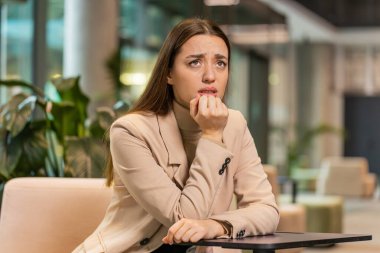 Depresyondaki Kafkasyalı genç iş kadını maddi sorunlar için endişeleniyor. Stresli serbest çalışan sinirli görünüyor. Para borcu, bütçe kaybı, modern ofis lobisinde iflas.