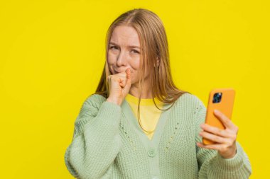 Üzgün, beyaz bir kadın akıllı telefon daktilo kullanıyor, oyun oynuyor, kaybediyor, piyango sonuçlarına şaşırıyor kötü şans kaybı şanssız haber. Sarı arka planda oldukça çekici bir kız.