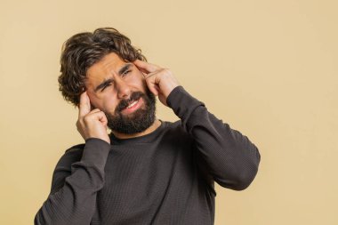 Uzun kollu Lübnanlı sakallı adam baş ağrısı problemini tedavi etmek için tapınakları ovalıyor, tansiyon, migren, stres, ekşitme, acı içinde yüksek tansiyon, bej rengi stüdyo arka planında tek başına izole edilmiş yüksek tansiyon.