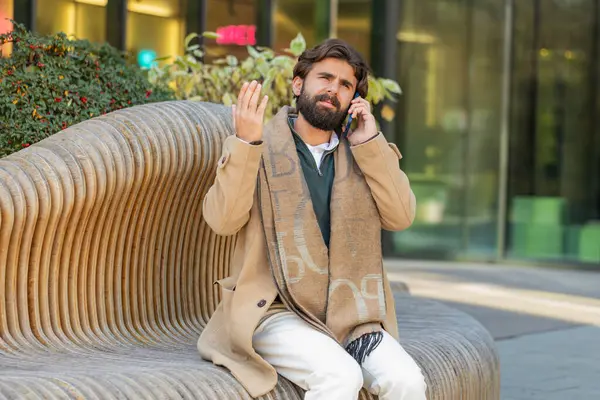 Hintli genç iş adamı. Stresli haberleri olan turist akıllı telefondan arıyor. Üzgün, kafası karışmış İspanyol sakallı adam şehir merkezinde tatsız bir telefon görüşmesi yapıyor.