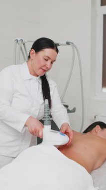 Masaj terapisi. Kozmetik doktoru kadına ultrason boşluğu LPG süpürge, yağ önleyici RF, sırt üstü kaplıca kaldırma prosedürü uyguluyor. Vücut şekillendirme tedavisi. Yağ tedavisi, düzeltme rakamları