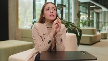 Depresyondaki Kafkasyalı genç iş kadını maddi sorunlar için endişeleniyor. Stresli serbest çalışan sinirli görünüyor. Para borcu, bütçe kaybı, modern ofis lobisinde iflas.