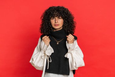 Sinirli, sinirli, Kafkasyalı bir kadın kızgın bir ifadeyle ellerini kaldırıyor, anlaşmazlık nedeni sorguluyor. Neden bu kadar inatçısın? Sinirli genç kız kırmızı arka planda izole edildi.