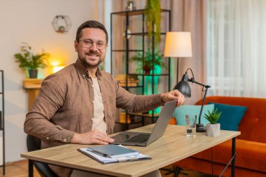 Kafkas genç iş adamı dizüstü bilgisayarı açıyor ve ofis masasında otururken proje üzerinde çalışıyor. Yetişkin adam internet üzerinde çalışıyor, mesajlar gönderiyor, online alışverişler yapıyor, film izliyor..