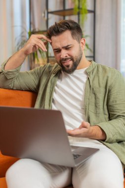 Evdeki koltukta oturan yorgun, kafkas bir adam dizüstü bilgisayar kullanıyor ve stresli. Şok olmuş esmer adam kaybına tepki veriyor, Netbook 'ta kötü haber oturma odasında. Bilgisayar virüsü.