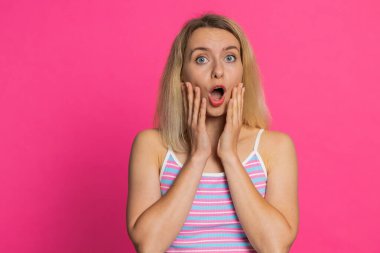 Aman Tanrım, vay canına. Heyecanlı, şaşırmış, şaşkınlık içinde, kazanan kadın kameraya bakarken büyük gözlerle başarıyı, başarıyı ve iyi haberi kutlayan ani zaferi görünce şok oldu. Pembe arka planda izole edilmiş kız