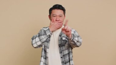 Hiçbir şey söylemeyeceğim. Katı Asyalı orta yaşlı adam elleriyle ağzını kapatıyor, kamera karşısında korkmuş görünüyor korkunç sırları anlatmayı reddetmiyor. Olgun Çinli adam.