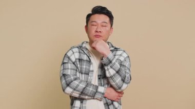 - İyi fikir. Asyalı ilham verici bir adam, ağzı açık bir şekilde işaret ediyor, plan yapıyor, işe koyuluyor, Eureka jest problemi çözümü için ilham veriyor. Çinli adam bej renkli stüdyo arka planında izole edilmiş.