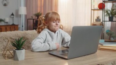 Genç bir kız dizüstü bilgisayarla masada oturuyor, evde kaybettiği bir maçtan sonra hayal kırıklığına uğruyor. Kafkasyalı çocuk üzgün bir ifadeyle hayal kırıklığı gösteriyor. Başarısızlık ve üzüntü duygularını yansıtıyor.