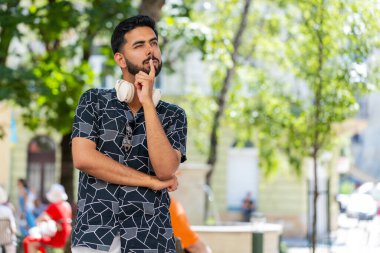 Düşünceli, düşünceli, düşünceli, düşünceli, genç Hintli bir adam. Düşünceli bir ifadeyle, bir çözüm düşünüyor, şüpheci bir soru soruyor, dışarıda hayaller kuruyor. Sakallı Hintli adam şehir caddesinde. Kasaba yaşam tarzları.