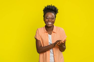 Aferin, aferin. Kadın sevinçle gülerken el çırpıyor, memnuniyet saçıyor ve alkışlıyor. Başarılı bir iş. Neşeli siyahi kız başını sallayarak başarıyı kutluyor.