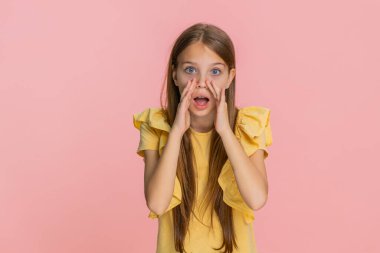 Küçük kız elleri ağızında bağırıyor, hoparlör kullanıyormuş gibi yapıyor. Pembe arka planda izole edilmiş okul çocuğu, cesur enerjiyle duygularını ve eğlenceli iletişimi ifade ediyor..