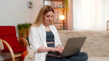 Orta yaşlı bir kadın evde bilgisayarını kapatıp önemli bir görevi başarıyla tamamlamasını kutluyor. Genç yetişkin kız tatmin ve rahatlama hissediyor, başarı anını kucaklıyor.