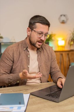 Ev ofisinin bilgisayarında çalışan mutlu iş adamı çalışanlarıyla online haberleşme videosu konuşması yapıyor, patron. Yönetici adam bilgisayarın webcam 'ine el sallayarak bakan servisleri destekler.