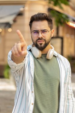 Hoşnutsuz, kötü bir fikre tepki veren, kötü kaliteden memnun olmayan, el sallayan, başını sallayan beyaz bir adam. Şehir sokağında genç bir gezgin..