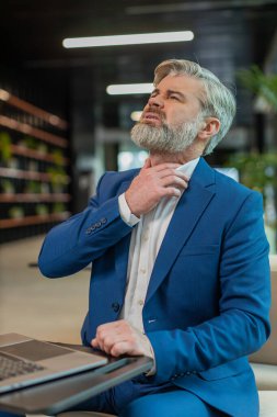 Hasta iş adamı telefonda boğazı ağrıyormuş, öksürüyormuş ve laptopla çalışıyormuş. Takım elbiseli stresli adam soğuk algınlığı ya da grip yüzünden ofis lobisinde çalışıyor. Üzgün işçi virüs kaptı, hastalık kaptı.