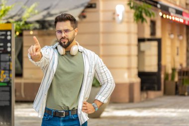 Hoşnutsuz, kötü bir fikre tepki veren, kötü kaliteden memnun olmayan, el sallayan, başını sallayan beyaz bir adam. Şehir sokağında genç bir gezgin..
