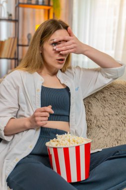 Orta yaşlı bir kadın evde TV 'de dramatik film sahneleri izler patlamış mısır yer ve gözleri merakla kapatır. Genç yetişkin bir kız duygusal olarak gerilim ve odaklanma ile sinematik bir ana dalmış olarak tepki verir.