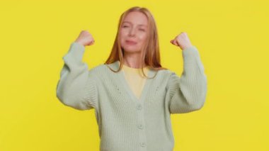 Ben güçlü ve bağımsızım. Mutlu gülümseyen beyaz kadın pazılarını gösteriyor, kendine güvenen, haklar için savaşacak gücü, başarı için enerjiyi hisseden kadın kazanıyor. Sarı arkaplanda izole edilmiş kız