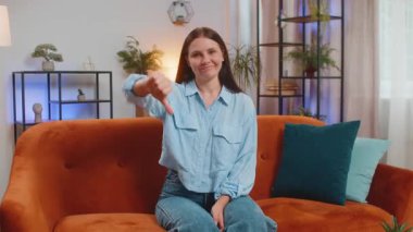 Hoşlanmamak. Mutsuz, genç, beyaz bir kadın işaret dilini gösteriyor. Memnuniyetsizliğini dile getiriyor. Memnuniyetsizliğini dile getiriyor. Kanepedeki hoşnutsuz kız