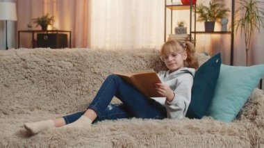 Genç kız masal kitabı okuyarak evinde dinleniyor, komik kısımlara hafifçe gülümsüyor. Kanepedeki sarışın çocuk olay ciddileştiğinde aniden iç çeker. Her sayfanın tadını sessizce çıkarır..