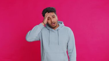 Üzgün genç Hintli adam umutsuzluk yalnızlık, sinir bozukluğu, kaybediyor piyango sonuçları, kötü talih, şanssız haberler karşısında şaşırıyor. Çekici Hindu adam pembe arka planda izole edilmiş.
